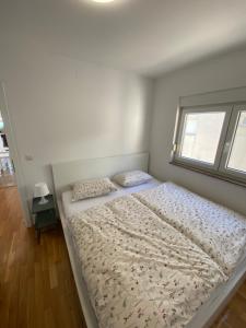 uma cama grande num quarto com uma janela em Tessitura Murter apartman em Murter