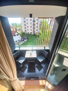 een kamer met een tafel en een groot raam bij Ema Lux in Zlatibor