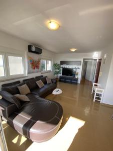 uma sala de estar com um sofá de couro e uma mesa em Tessitura Murter apartman em Murter
