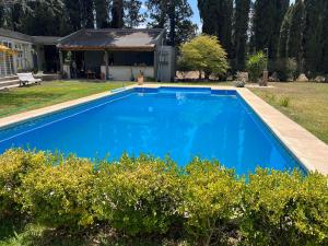a blue swimming pool in front of a house at Casa de fin de semana El Ancla in Campos Salles +27 photos
