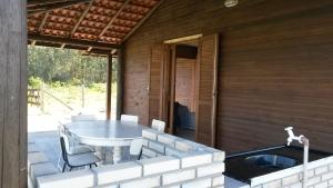 a patio with a table and chairs on a house at Casa De Praia Galheta in Farol de Santa Marta