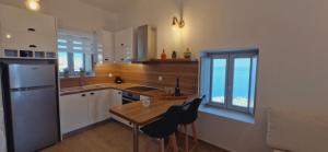 a kitchen with a wooden table and a refrigerator at Aloni in Áno Meriá