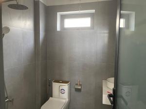 La salle de bains est pourvue de toilettes et d'une fenêtre. dans l'établissement My Hoa Oceanfront Home, à Ấp Mỹ Hải