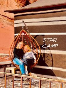 Due ragazze sono sedute in un'altalena di STAR CAMP & WiTH TOR a Wadi Rum