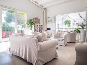 a living room with white furniture and large windows at Hotel Capo Sud in Lacona