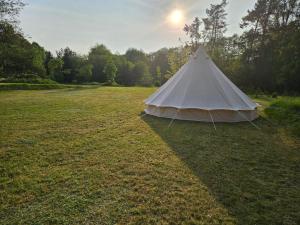 a white tent in the middle of a field at Tipi Camping in der Mecklenburgischen Seenplatte in Carpin