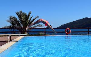 een man springt in een zwembad bij Hotel Capo Sud in Lacona