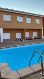une piscine en face d'un bâtiment dans l'établissement Apartament Els Flamencs, à Els Muntells