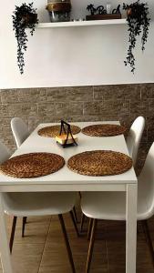 a white table with four chairs and a white table with fouritures at Apartamento Casa el Canario in Costa Teguise