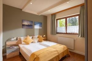 Schlafzimmer mit einem Bett und einem Fenster in der Unterkunft Bergviewhaus Apartments in Söll
