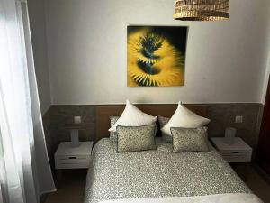 a bedroom with a bed with two tables and a painting at Apartamento Casa el Canario in Costa Teguise +11 photos