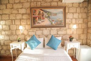 a room with a white bed with blue pillows at Alaçatı Kavalalı Otel in Alaçatı