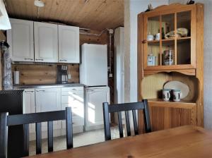 a kitchen with a refrigerator and a table and chairs at Lomamökki Kuhmo, Tervatörmä in Kuhmo