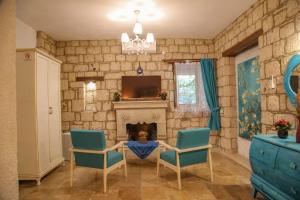 sala de estar con mesa, sillas y chimenea en Alaçatı Kavalalı Otel, en Alacati