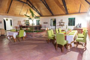 een restaurant met tafels en groene stoelen en een fontein bij Sharp Island Gorilla Lodge, Lake Bunyonyi in Kashasha