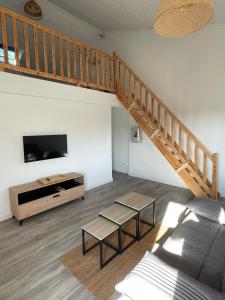 a living room with a staircase and a television at Oustaou di Ercole in Bormes-les-Mimosas