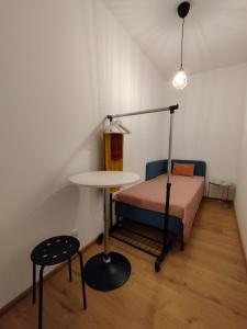 Villa Natali Warszawa في وارسو: غرفة صغيرة بها سرير وطاولة