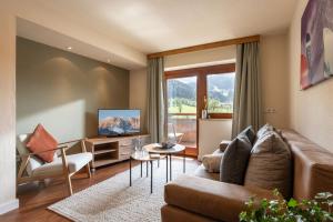 ein Wohnzimmer mit einem Sofa und einem TV in der Unterkunft Bergviewhaus Apartments in Söll