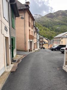 an empty street in a town with buildings and cars at Studio cocooning à Cauterets 2 adultes et 1 enfant in Cauterets
