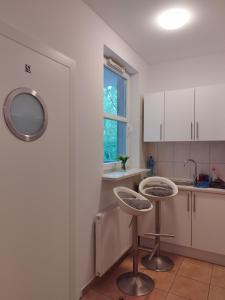a kitchen with two stools in front of a window at Villa Natali Warszawa in Warsaw