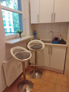 a kitchen with two stools in front of a sink at Villa Natali Warszawa in Warsaw