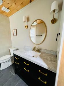 uma casa de banho com um lavatório e um espelho em The Tellico Plains Inn and Event Venue em Tellico Plains