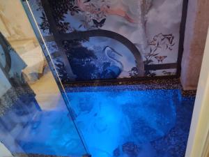 a swimming pool in a room with a painting on the wall at Victoria's Home in Faccia di Trippa