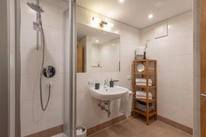 ein Bad mit einem Waschbecken und einer Dusche in der Unterkunft Bergviewhaus Apartments in Söll
