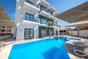 a swimming pool in front of a building at Absolute Hotel Ksamil in Ksamil