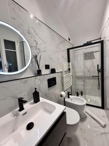 bagno con lavandino, servizi igienici e specchio di Casa Jolie - vista castello a Dolceacqua
