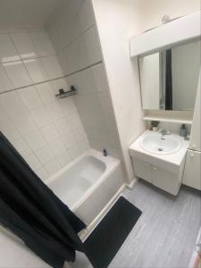 Baño blanco con bañera y lavamanos en Appartement in hartje lier, en Lier