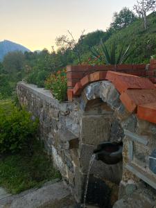 una pared de piedra con una fuente de agua en Guest House Laci, en Tirana