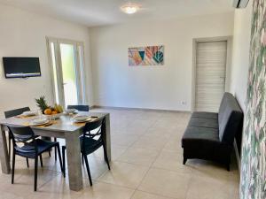 a dining room with a table and chairs and a couch at La Campanula-exclusive pool in Santa Maria a Monte