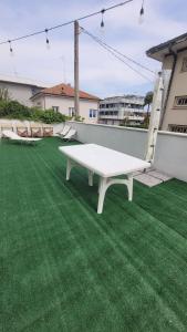 uma mesa de pingue-pongue branca num relvado verde em Appartamento estivo PONENTE - Misano A.(RN) em Misano Adriatico