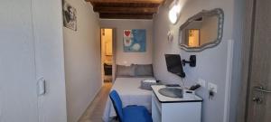 パレルモにあるA Casa Di Lillyのベッド、デスク、鏡が備わる小さな客室です。