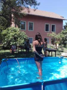 a woman is standing in a swimming pool at Budapest Garden Hostel in Budapest