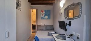 Habitación pequeña con cama y espejo. en A Casa Di Lilly, en Palermo