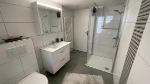 a bathroom with a shower and a toilet and a sink at Ferienwohnung Edelweiss in Wolfhalden  +18 photos