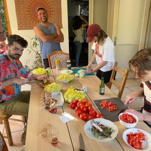 Budapest Garden Hostel في بودابست: مجموعة من الناس يجلسون حول طاولة مع الطعام