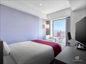 a hotel room with a bed and a large window at Daiwa Roynet Hotel Aomori in Aomori