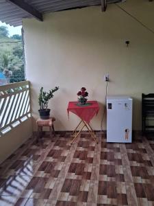Habitación con mesa roja y nevera pequeña. en Casa da teka, en Pedro de Toledo