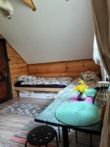 een kleine kamer met een tafel en een bed bij Domek w Łupkowie in Komańcza