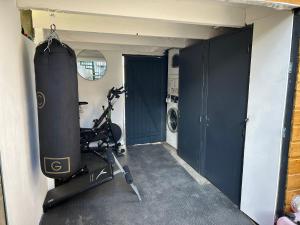 um quarto com um ginásio com uma passadeira e um quarto com uma máquina de lavar roupa em Reve Divin T4 avec parking-barbecue-laverie-bagagerie-salle de sport-aire de jeux em Lourdes