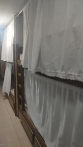 a bedroom with a white curtain on the wall at Repouso do corcovado hostel in Rio de Janeiro