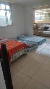 a room with two beds and a couch in a room at Repouso do corcovado hostel in Rio de Janeiro