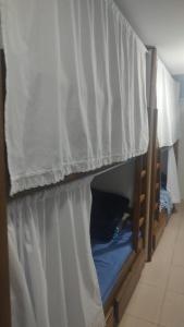 a bunk bed with a white curtain in a room at Repouso do corcovado hostel in Rio de Janeiro
