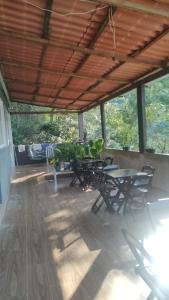 un patio con mesas y sillas en un porche en Repouso do corcovado hostel, en Río de Janeiro