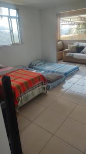 um quarto com 2 colchões num piso de azulejo em Repouso do corcovado hostel no Rio de Janeiro