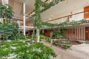 een gebouw met een binnenplaats met een boom erin bij Luxury 3 beds Villa inside the Resort and Country Club in Estepona