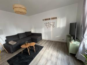 sala de estar con sofá y mesa en Casa Nella, centre et parking, madamedemconciergerie, en Reims